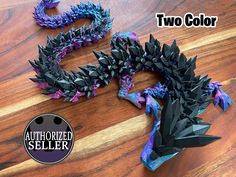 two black and purple dragon sculptures sitting on top of a wooden table