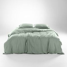 an image of a bed that is made up with green sheets and pillowcases