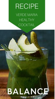 a green drink in a glass on top of a wooden table