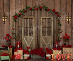 a wooden wall with two doors and red roses on the floor next to it is a sign that says love