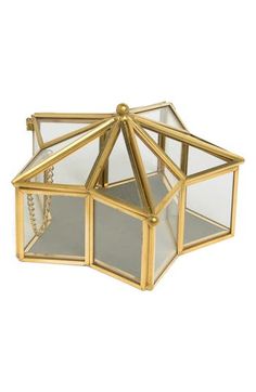 a small glass box with gold trimmings on the top and bottom, sitting in front of a white background