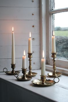 four candles sitting on top of a window sill