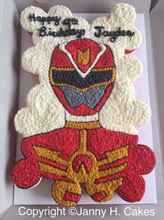 a birthday cake in the shape of a red and yellow power rangers figure with happy birthday written on it