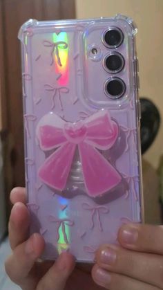 a person holding up a phone case with a pink bow on the front and side