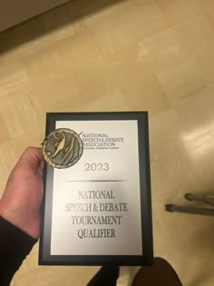 a person holding up an award plaque for national speech and debate tournament quality assurancer