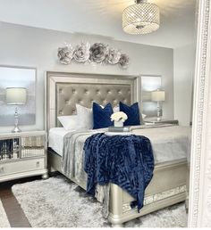 a bedroom with a bed, dressers and mirror in it's center area