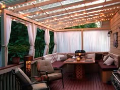 a covered patio with seating and string lights