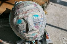 a paper mache head sitting on top of newspaper