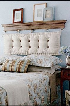 a bedroom with blue walls and white bedding, two framed pictures on the headboard