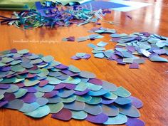 the table is covered with purple and blue paper hearts that have been cut into smaller pieces