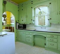 a kitchen with green cabinets and white appliances