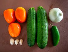 cucumbers, tomatoes, and garlic on a table