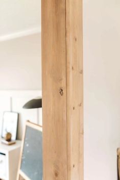 a tall wooden pole sitting in the middle of a living room next to a computer desk