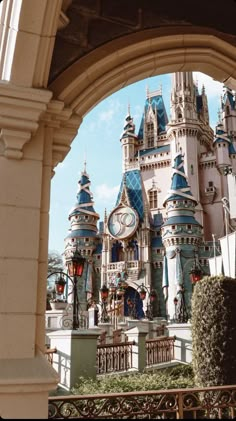 an archway leading to a castle with a clock on it's front and side