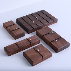 four wooden jewelry boxes with rings on them