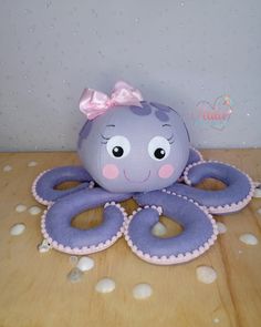 an octopus stuffed animal sitting on top of a wooden table