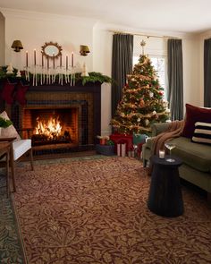 a living room filled with furniture and a christmas tree in front of a fire place