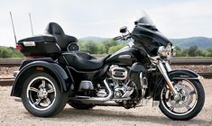 a black motorcycle parked on top of a gravel road