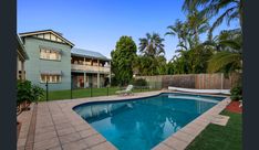 an empty swimming pool in the middle of a backyard with grass and trees around it