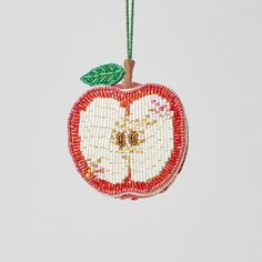 an apple ornament hanging from a string