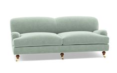 a light green couch sitting on top of a white floor next to a wooden frame