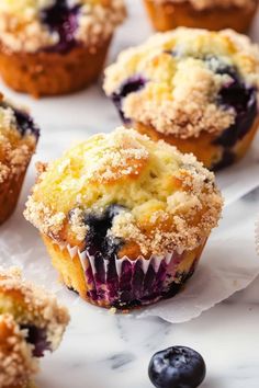 blueberry muffins with powdered sugar and fresh blueberries on the side