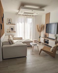 a living room filled with furniture and a flat screen tv on top of a wooden stand