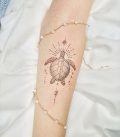 a woman's arm with a turtle and star tattoo on the left side of her arm