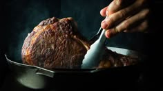 a person is eating some food from a bowl with a spoon in their hand,