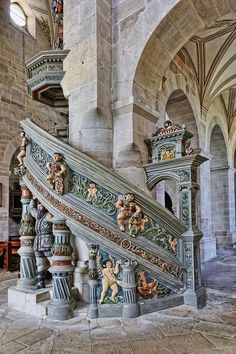 an ornate stair case in the middle of a building with sculptures on it's sides