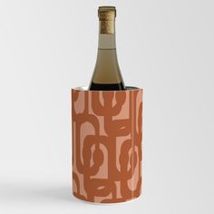 a bottle of wine in a cup with a pattern on the side and a cork top