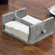 a napkin dispenser sitting on top of a wooden table