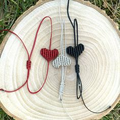 two pieces of beaded heart necklaces sitting on top of a piece of wood