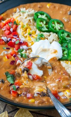 a bowl of mexican soup with tortilla chips and sour cream on the side