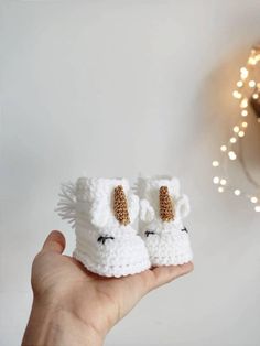 someone is holding up their tiny crocheted animal slippers in front of the wall