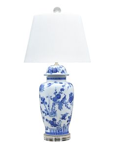 a blue and white vase with a lamp on it