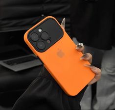 a person holding an orange iphone case in their hand