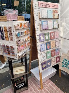 two display boards with different types of cards and papers on them in front of a store