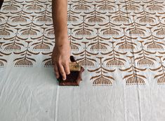 a person with their hand on a piece of wood