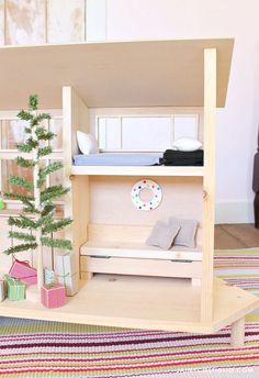 a doll house with furniture and accessories on the floor in front of a christmas tree