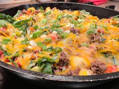 a skillet filled with lots of food on top of a table