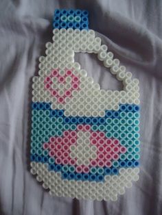 a handbag made out of plastic beads on a white sheet with pink and blue designs