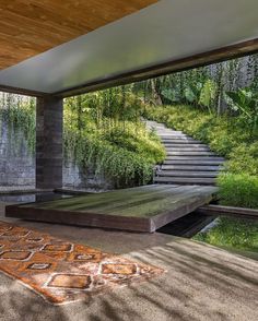 an outdoor area with stairs and water feature in the center, surrounded by greenery