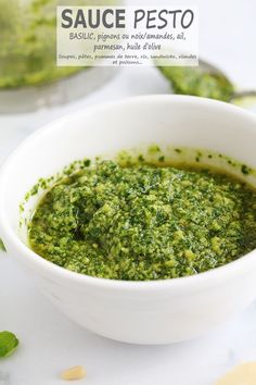 a white bowl filled with pesto on top of a table