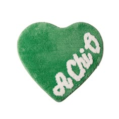 a green heart shaped pillow with the word love in white letters on it's side