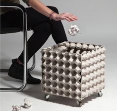 a person is sitting on a chair and throwing paper