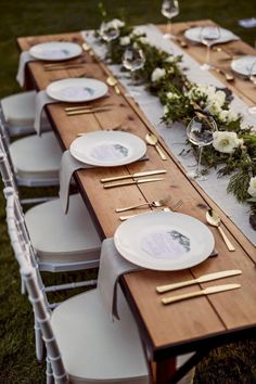 the table is set with white plates and silverware