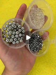 two plastic containers filled with black and silver beads