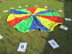 a colorful kite sitting on top of a lush green field next to numbered numbers in front of it