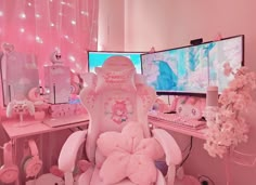 a desk with two computer monitors and a pink teddy bear chair in front of it